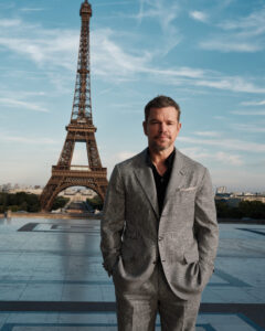 The cast of The Odyssey gathers in Paris beneath the Eiffel Tower for a twilight photo shoot.