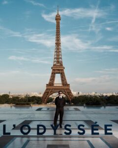 The cast of The Odyssey gathers in Paris beneath the Eiffel Tower for a twilight photo shoot.