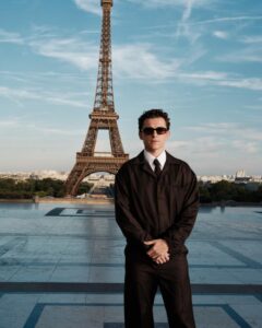 The cast of The Odyssey gathers in Paris beneath the Eiffel Tower for a twilight photo shoot.