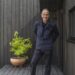 Kevin McCloud stands outside a dark timber home in Grand Designs UK season 24.