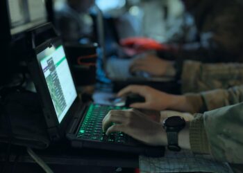 People using laptops in a military-style setting for Four Corners Click to Kill The AI War Machine