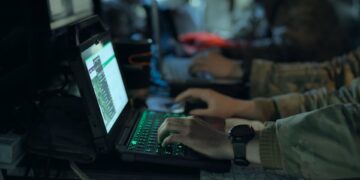 People using laptops in a military-style setting for Four Corners Click to Kill The AI War Machine