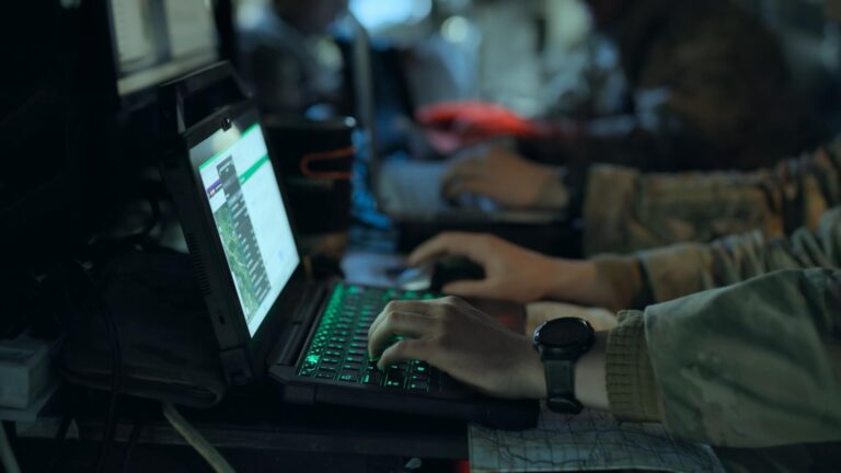 People using laptops in a military-style setting for Four Corners Click to Kill The AI War Machine