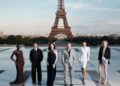 The cast of The Odyssey gathers in Paris beneath the Eiffel Tower for a twilight photo shoot.