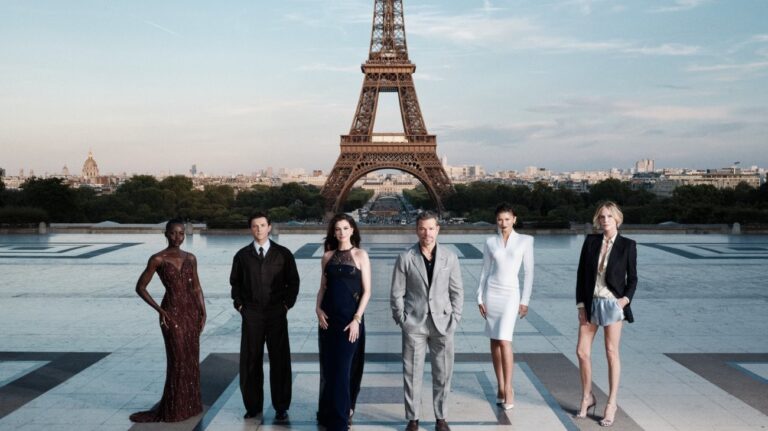 The cast of The Odyssey gathers in Paris beneath the Eiffel Tower for a twilight photo shoot.