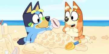 Bluey and Bingo on the beach in a still from Bluey.