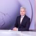 Anton Enus seated at the SBS World News desk