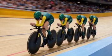 Australian women's pursuit cyclists ride in formation on an indoor velodrome