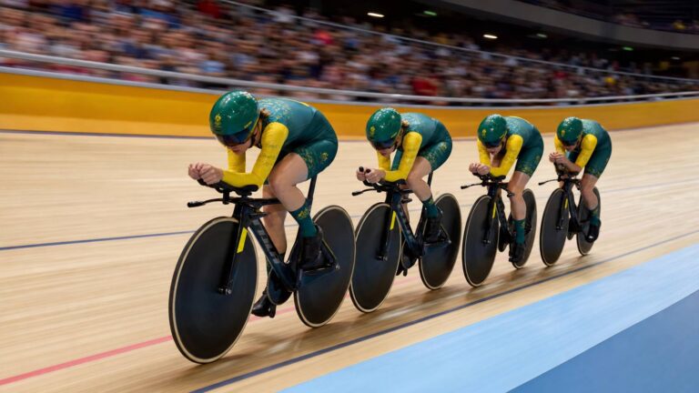 Australian women's pursuit cyclists ride in formation on an indoor velodrome