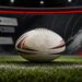 Rugby league ball on a field with a phone and social media comments in the background.