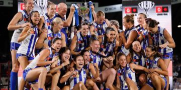 North Melbourne players celebrate with the AFLW premiership cup