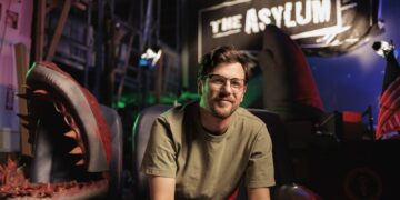 Mockbuster director Anthony Frith on a creature-film set beneath The Asylum sign