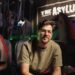 Mockbuster director Anthony Frith on a creature-film set beneath The Asylum sign