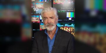 Shaun Micallef in front of studio screens promoting Parents' Evening