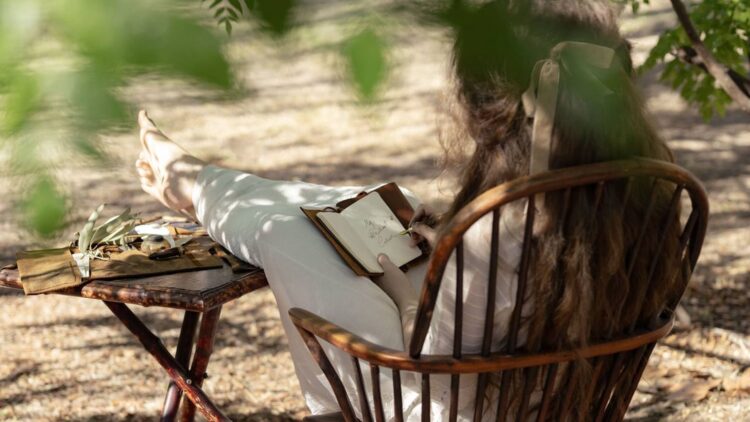 A young woman writing outdoors in an official image for Netflix's The Next Brilliant Career screenwriter initiative