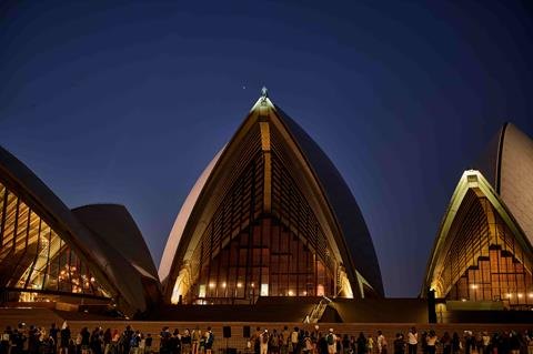 The Sydney Opera House illuminated at dusk during the Batman Day 2026 event.