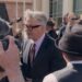 Alec Baldwin surrounded by cameras outside a courthouse