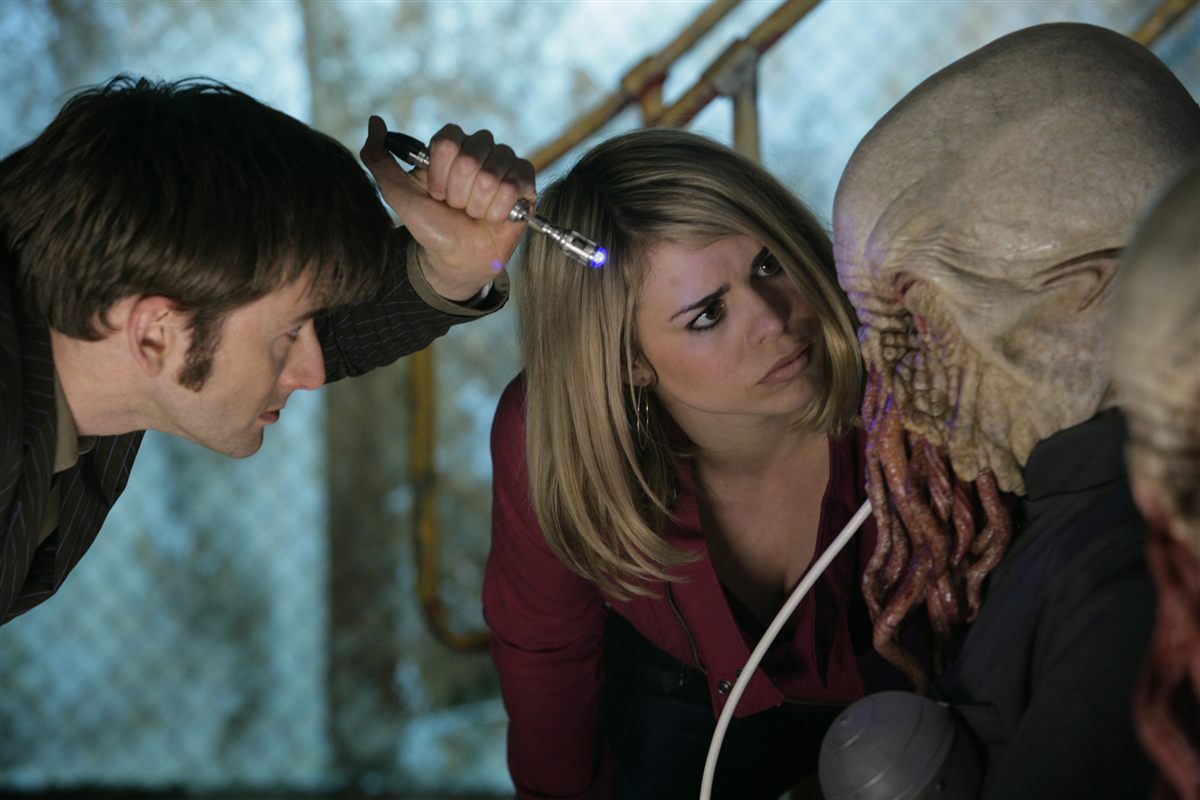 David Tennant as the Tenth Doctor and Billie Piper as Rose Tyler examining an Ood