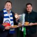 David King and Leigh Montagna pose with breakfast dishes and the premiership cup ahead of the 2026 North Melbourne Grand Final Breakfast.