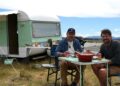 Colin Fassnidge and Manu Feildel beside their caravan in Aotearoa