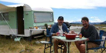 Colin Fassnidge and Manu Feildel beside their caravan in Aotearoa