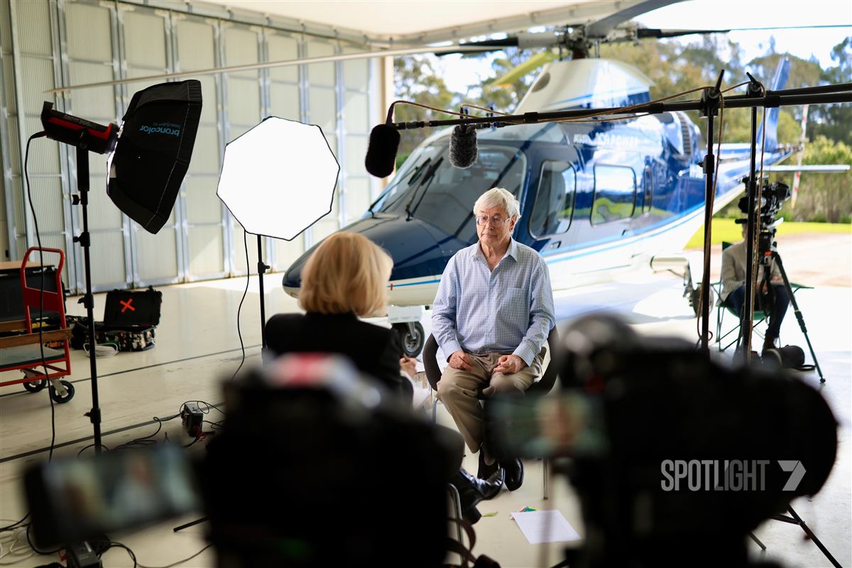 Dick Smith being interviewed by Liz Hayes beside a helicopter for 7NEWS Spotlight