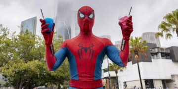 Spider-Man holding two spider drinks in Sydney for the Brand New Day fan pop-up