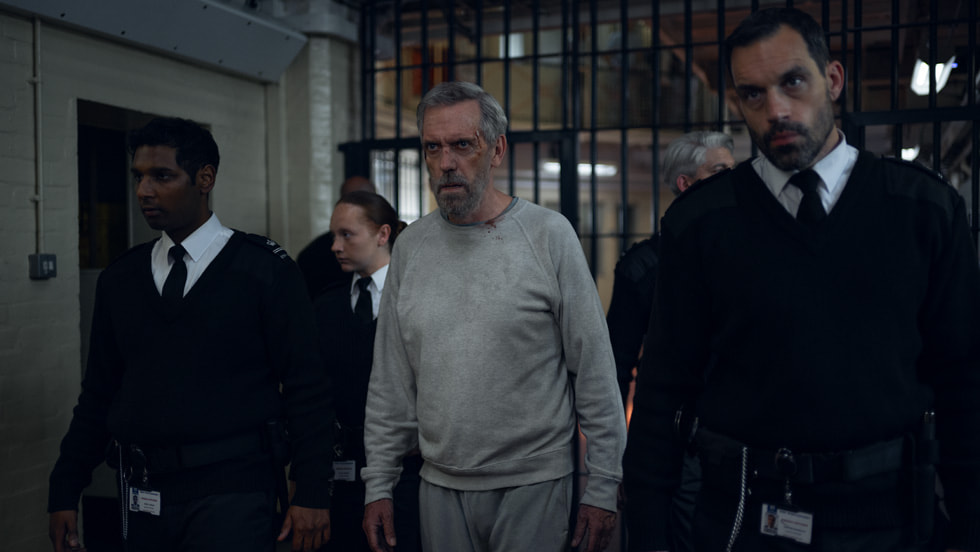 Hugh Laurie as Felix Carmichael being escorted through prison in The Wanted Man