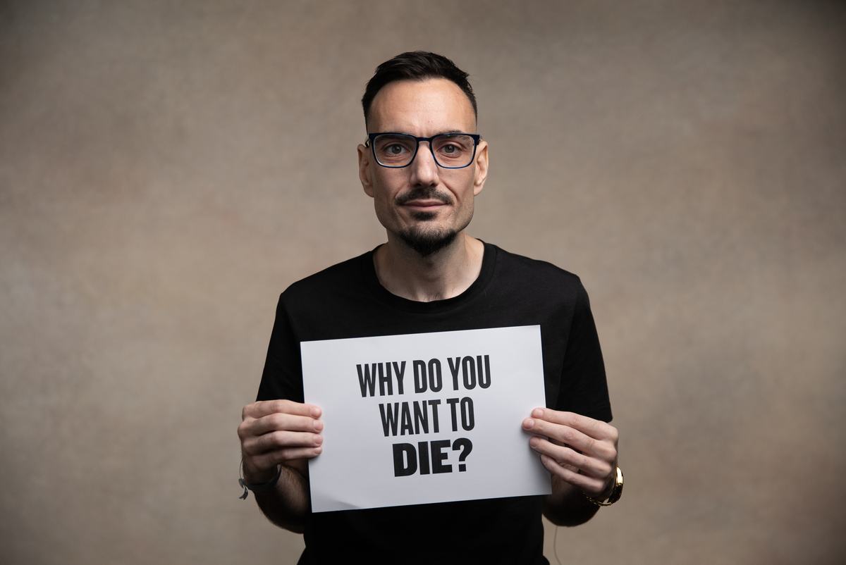 A participant holds a direct question for You Can't Ask That