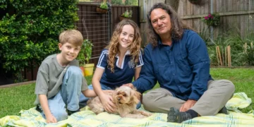 Two children and a presenter on a picnic rug with a dog in Gardening Australia Junior on ABC Kids