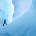 An explorer walks between towering blue ice formations in Ages of Ice