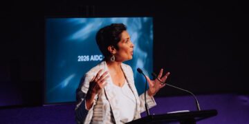 Speaker addresses the 2026 AIDC conference at a lectern