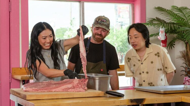 Awkwafina prepares food with two chefs in The Unlikely Cook