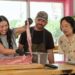 Awkwafina prepares food with two chefs in The Unlikely Cook