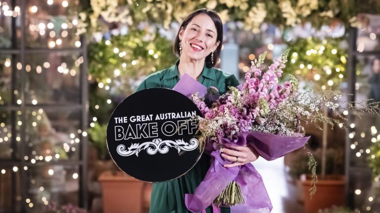 Pamela Buchanan holding her Great Australian Bake Off winner trophy and flowers