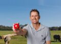 Mark Howard holding a red cricket ball in Fox Cricket publicity imagery