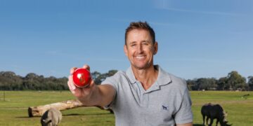 Mark Howard holding a red cricket ball in Fox Cricket publicity imagery