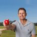 Mark Howard holding a red cricket ball in Fox Cricket publicity imagery