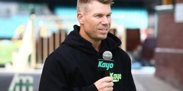 David Warner speaking into a Kayo Sports microphone
