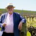 News24 Wine and Travel Editor Des Houghton holding a glass of white wine in a vineyard