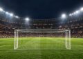 Illustrative football stadium and goal under floodlights