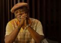 Samuel L. Jackson as Russell Lee Washington Jr. sits at a table covered in cash in Frisco King