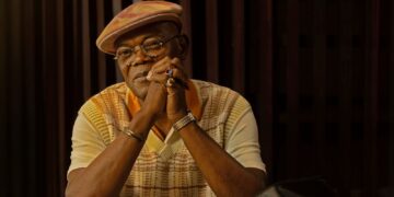 Samuel L. Jackson as Russell Lee Washington Jr. sits at a table covered in cash in Frisco King