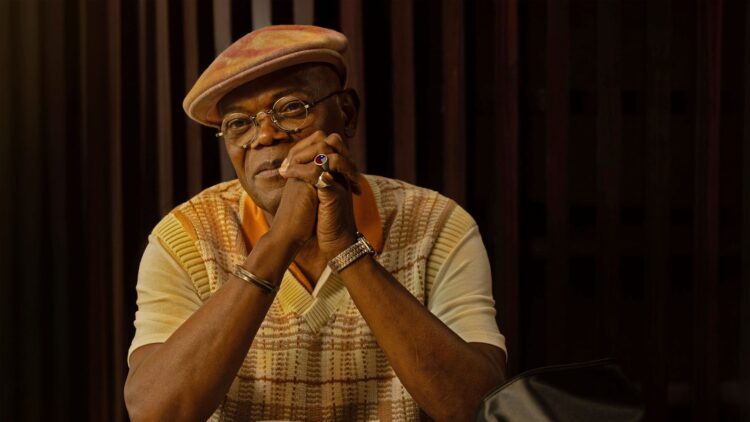 Samuel L. Jackson as Russell Lee Washington Jr. sits at a table covered in cash in Frisco King