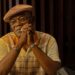 Samuel L. Jackson as Russell Lee Washington Jr. sits at a table covered in cash in Frisco King