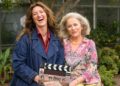Kate Box and Sarah Peirse holding a Help Me! clapperboard in Sydney