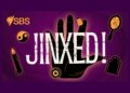 Official purple artwork for SBS Audio podcast Jinxed! featuring a black hand surrounded by superstition symbols