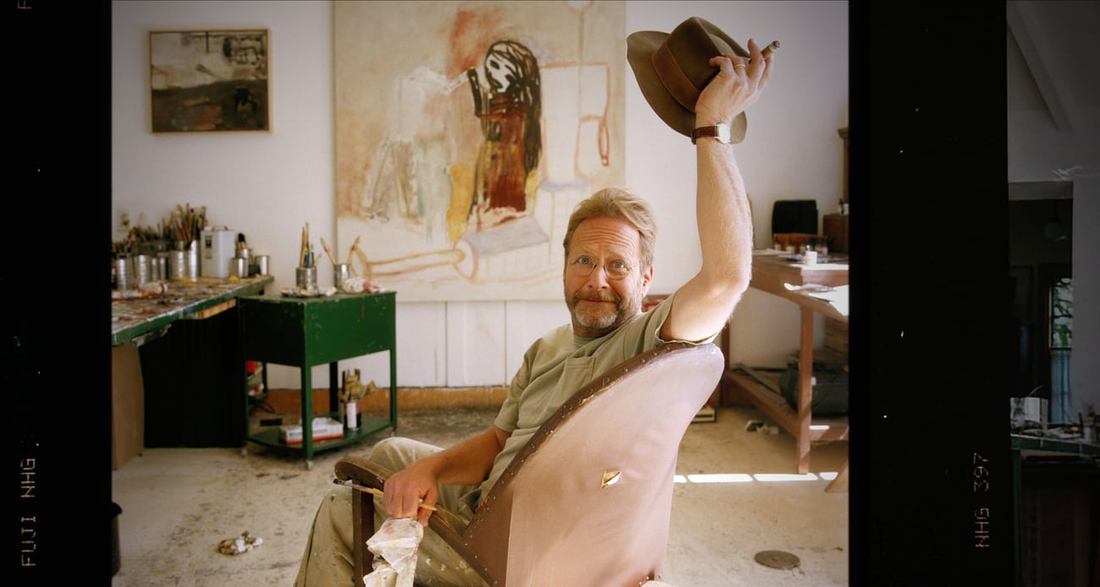 Martin Mull seated in an art studio