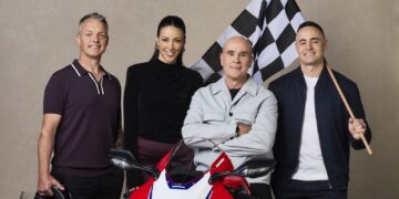 10's MotoGP commentary team Cameron Donald, Tara Rushton, Daryl Beattie and Sam Charlwood with a Honda motorcycle and chequered flag