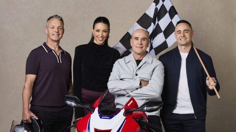 10's MotoGP commentary team Cameron Donald, Tara Rushton, Daryl Beattie and Sam Charlwood with a Honda motorcycle and chequered flag